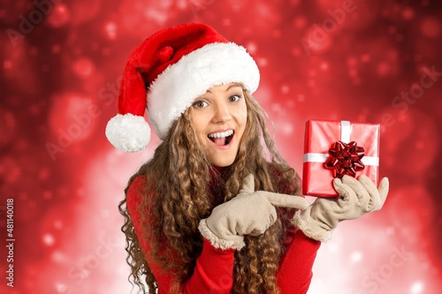 Young woman in red hat Santa Claus Christmas with gift. Happy New Year 2022 concept