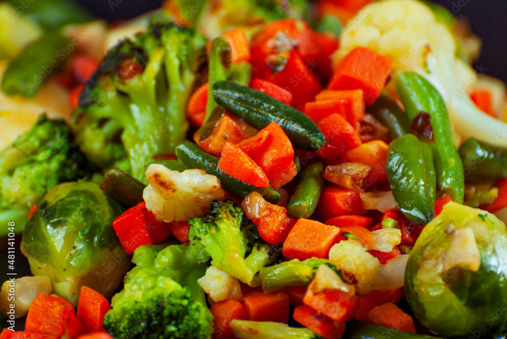 Mix of vegetables close up. Salad of various chopped vegetables. Roasted cabbage, carrots, broccoli, peas on a plate. Mix of vegetables close up. Salad of various chopped vegetables. Roasted cabbage, carrots, broccoli, peas on a plate.