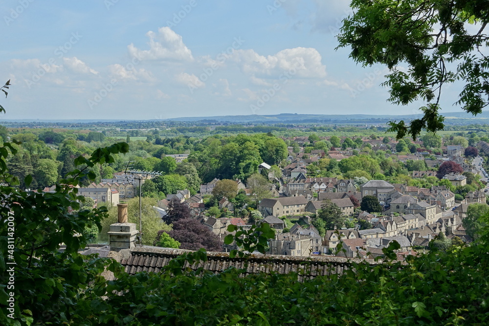 Scenic view of a beautiful old town set amongst leafy green trees seen from a high vantage point - namely the historic town of Bradford on Avon in Wiltshire England