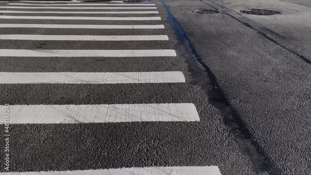 POV a person walks along a crosswalk. Zebra crossing in the city. POV a person walks along a crosswalk. Zebra crossing in the city.