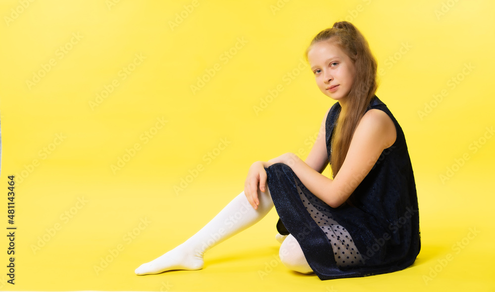 Portrait of a teenage girl in an elegant dress. Yellow background Portrait of a teenage girl in an elegant dress. Yellow background