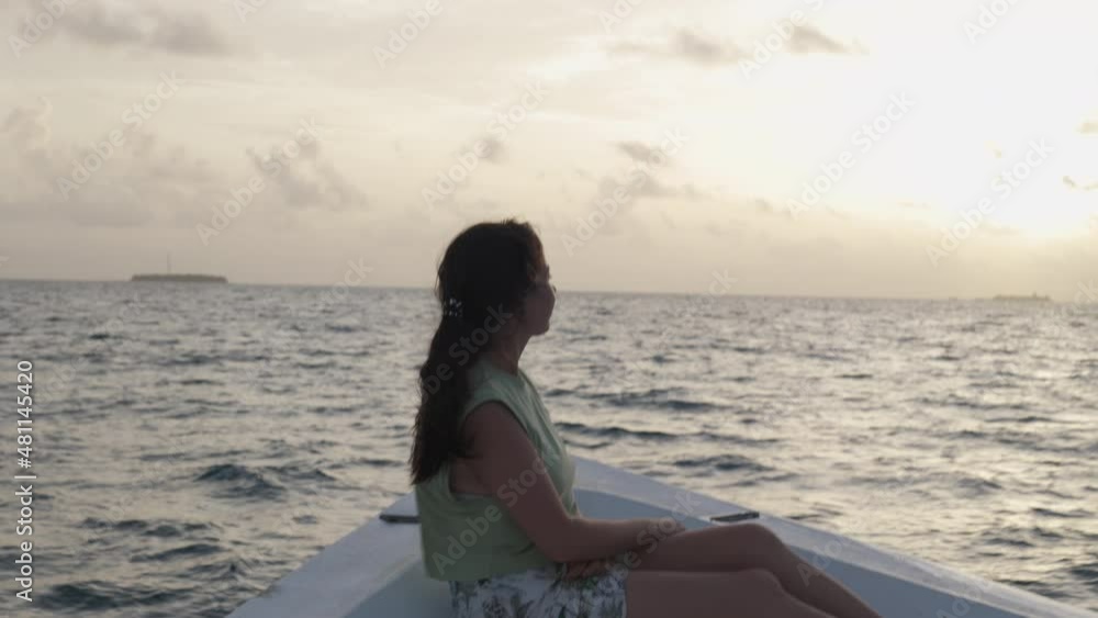Cruise boat vacation travel concept. Woman enjoying beautiful sunset at sea on the Indian ocean in Maldives. Freedom and calm Cruise boat vacation travel concept. Woman enjoying beautiful sunset at sea on the Indian ocean in Maldives. Freedom and calm