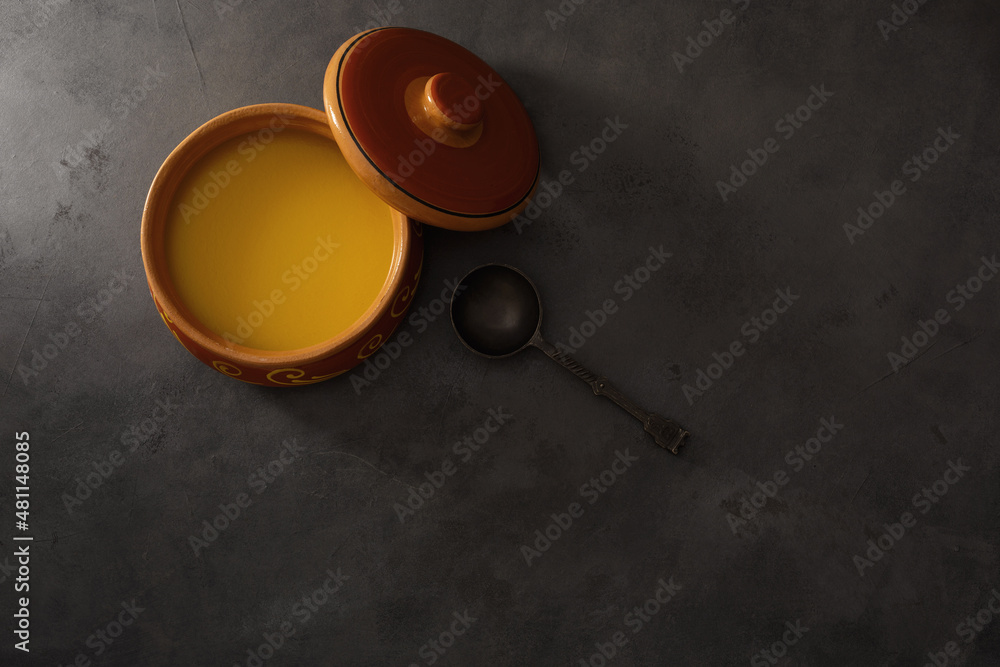.Pure OR Desi Ghee also known as clarified liquid butter. Pure OR Desi Ghee in ceramic bowls on an old wooden table.