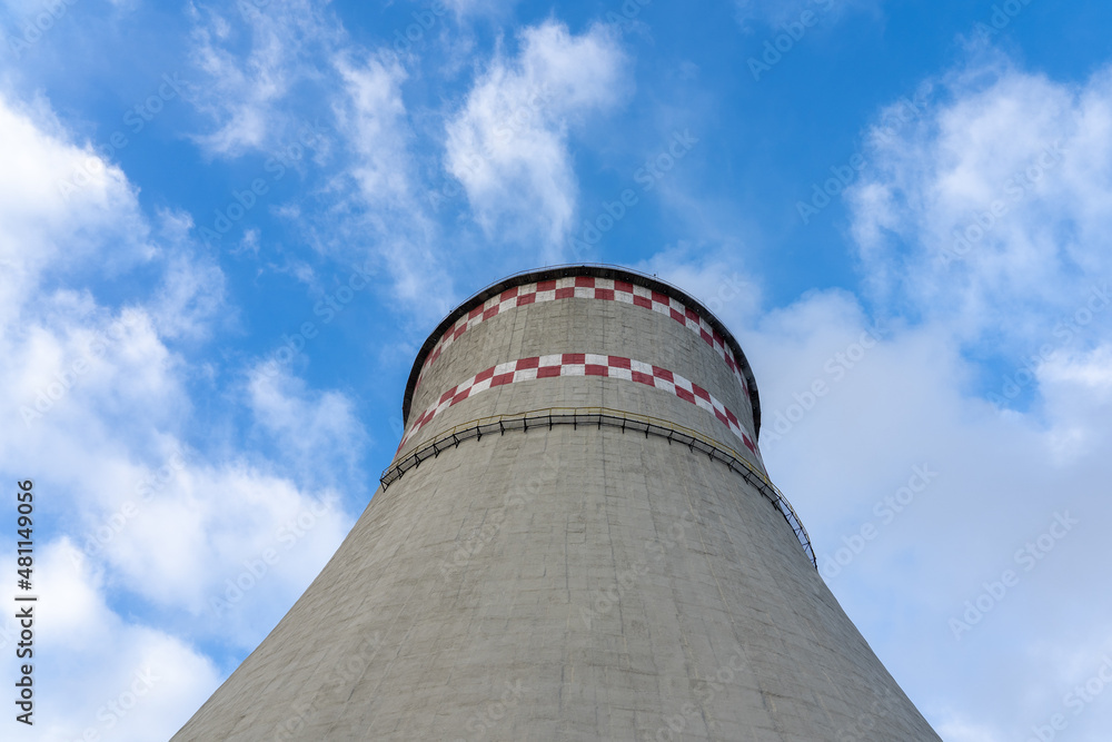 CHP pipe for cooling liquid after heating. A large chimney against the yearly sky. CHP pipe for cooling liquid after heating. A large chimney against the yearly sky.