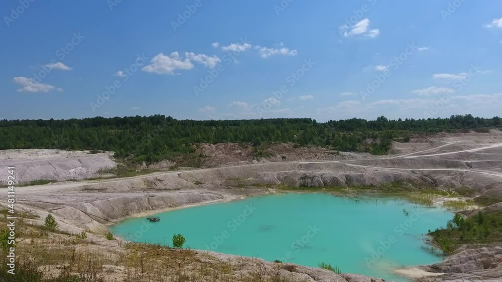 Beautiful landscape of kaolin quarry. Deep clay mine filled with water. Blue sky reflecting in the pond. Beautiful landscape of kaolin quarry. Deep clay mine filled with water. Blue sky reflecting in the pond.