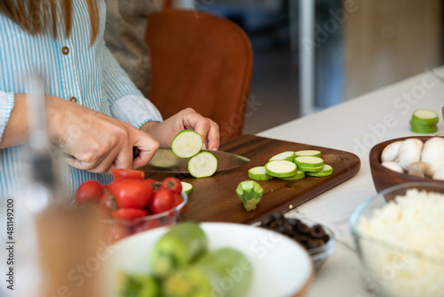 Zucchini cutting. Woman chopping zucchini on cutting board