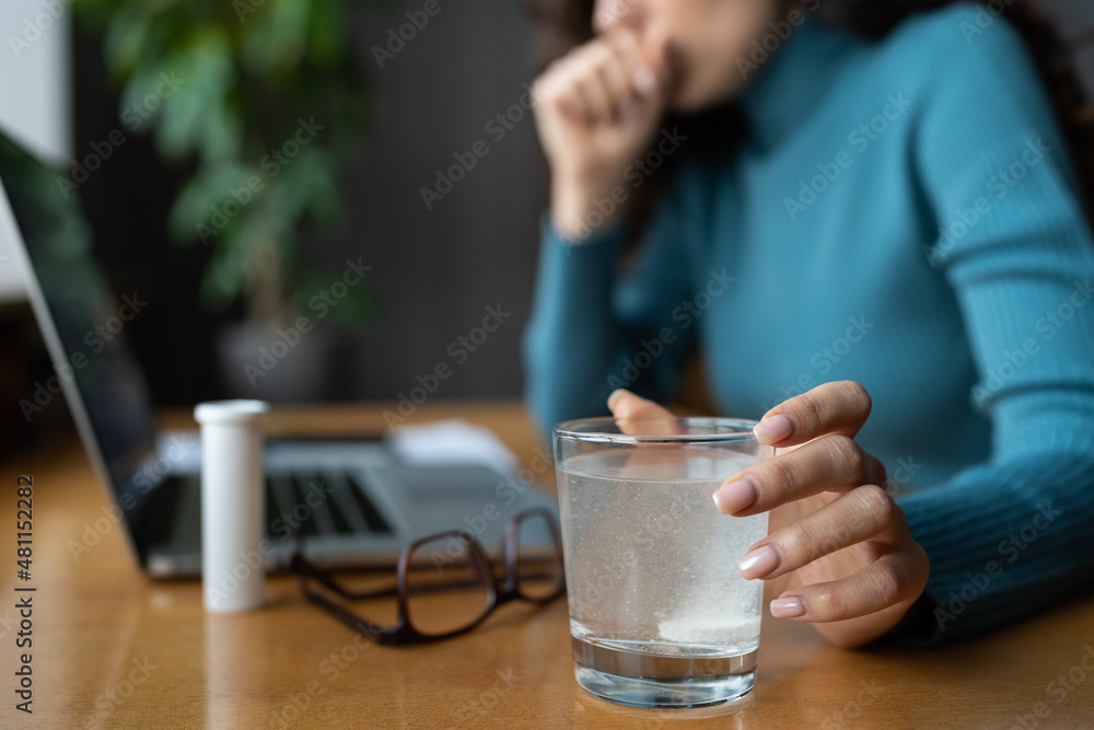 Closeup of painkiller aspirin dissolving in glass of water. Sick businesswoman taking medical pill at office workplace, suffering from migraine headache, feeling bad addicted to antidepressant tablets Closeup of painkiller aspirin dissolving in glass of water. Sick businesswoman taking medical pill at office workplace, suffering from migraine headache, feeling bad addicted to antidepressant tablets