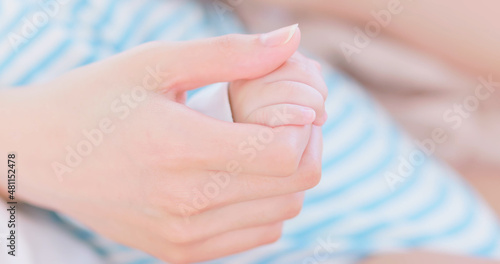 mom holds baby hand