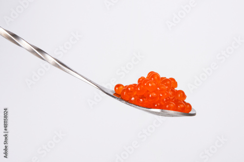 Red caviar in silver spoon isolated on the white background
