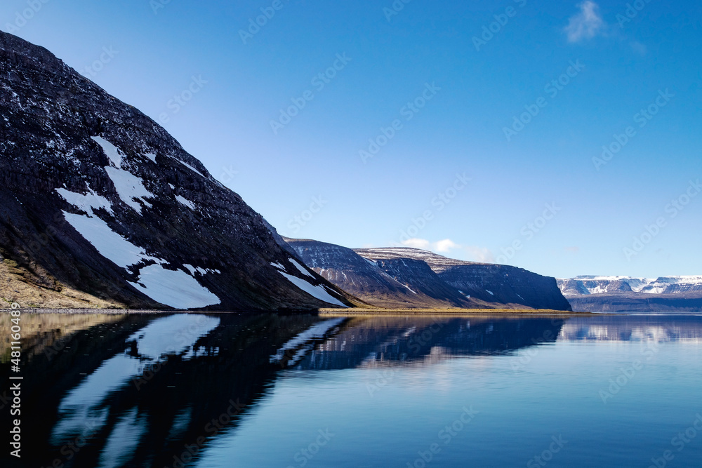 Beautiful mountains with a snow and reflection in the Atlantic ocean. Westfjords, Iceland.