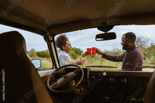 Black couple laughing and having shack during journey on trailer