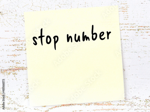 Yellow sheet of paper with word stop number. Reminder concept photo