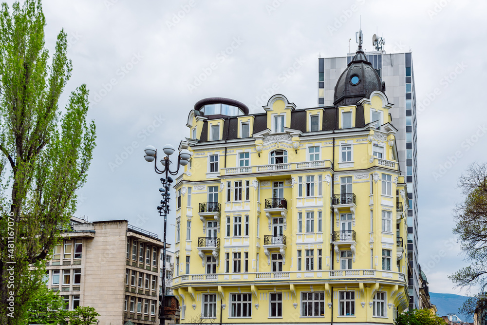 Beautiful renovated yellow facade of an old neo-baroque building. The house is designed in a Viennese pattern with terraces, bay windows  and a richly ornamented facade, Sofia, Bulgaria.