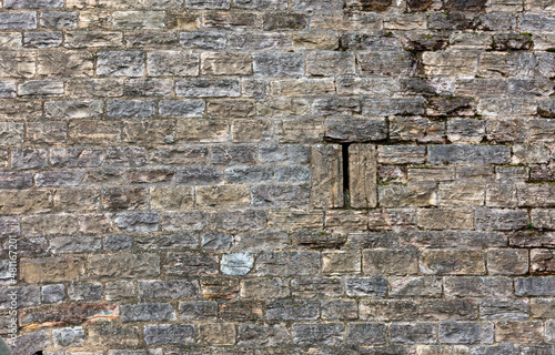 Wall of old fortress made with bricks, that were carved from stone photo