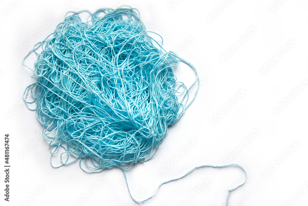The concept of brainstorming. A tangle of mint, blue cotton threads, needlework yarn on a white background. The concept of brainstorming. A tangle of mint, blue cotton threads, needlework yarn on a white background.