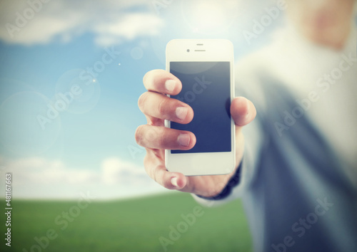 Presenting the newest smartphone. A young man holding his smartphone towards the camera.