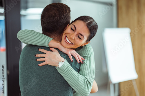 Attractive caucasian woman, respectfully hugging her teammate at the office.