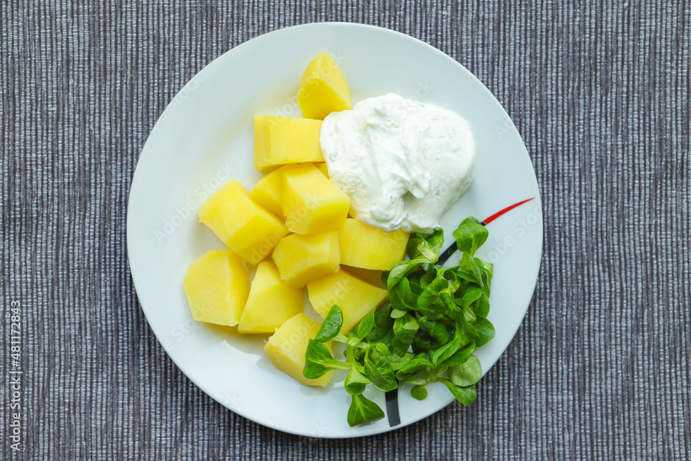 Potatoes with herb quark and lamb's lettuce on a plate Potatoes with herb quark and lamb's lettuce on a plate