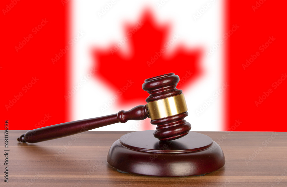 Wooden gavel in background of Canadian flag Wooden gavel in background of Canadian flag
