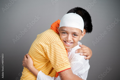 Happy Hindu Muslim Children embracing Each Other and looking camera with smile - Concept of friendship, togetherness, unity in diversity and freedom of religion photo