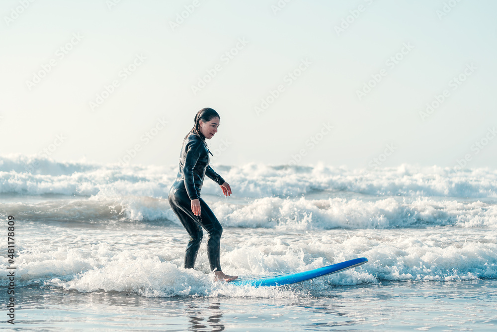 young woman learning to surf the waves alone young woman learning to surf the waves alone