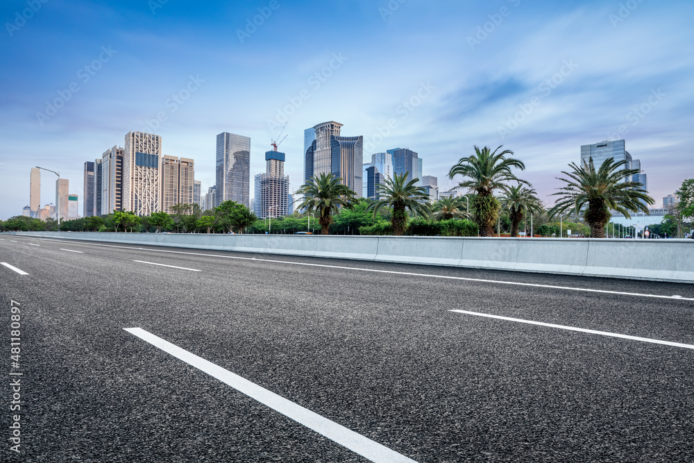 Asphalt road and city skyline with modern commercial office buildings in Shenzhen, China.