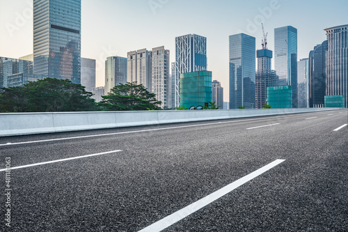 Asphalt road and city skyline with modern commercial office buildings in Shenzhen, China.