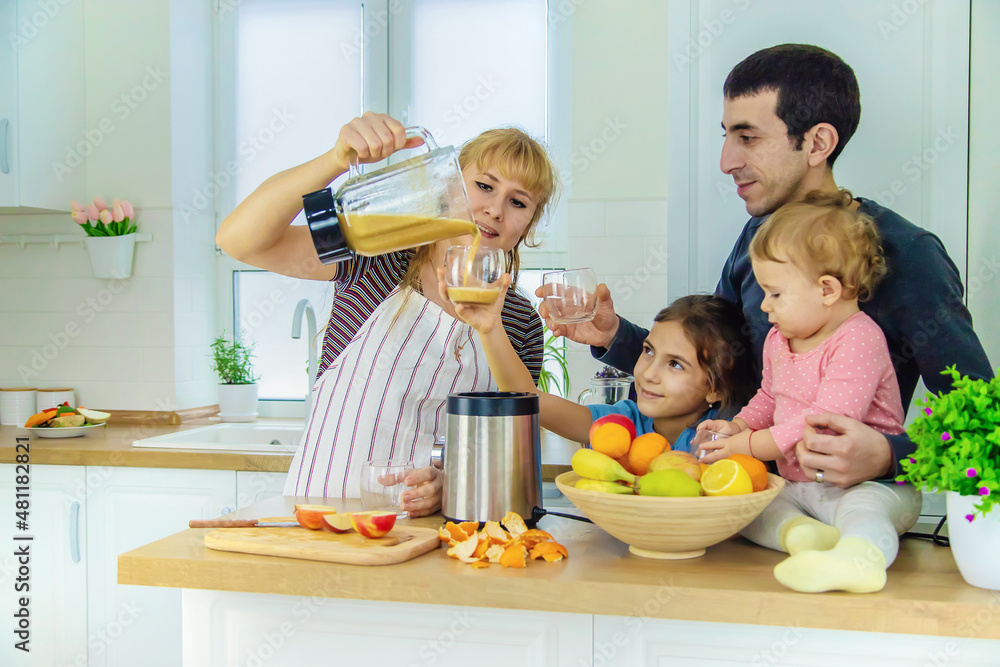 The family is making smoothies in the kitchen. Selective focus. The family is making smoothies in the kitchen. Selective focus.