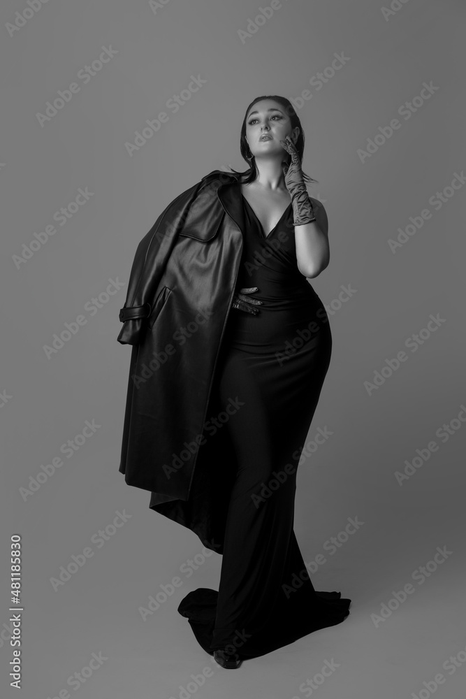 Full-length monochrome portrait of young beautiful woman posing isolated on gray studio background. Beauty, fashion, style, bodypositive concept