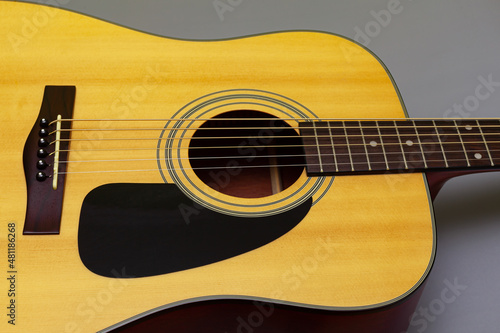  upper soundboard of an acoustic yellow guitar close-up on a gray background photo