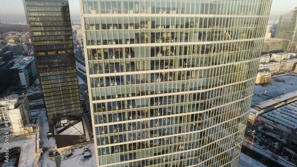 Aerial fast descending shot of a modern office building in the business district during the pandemic