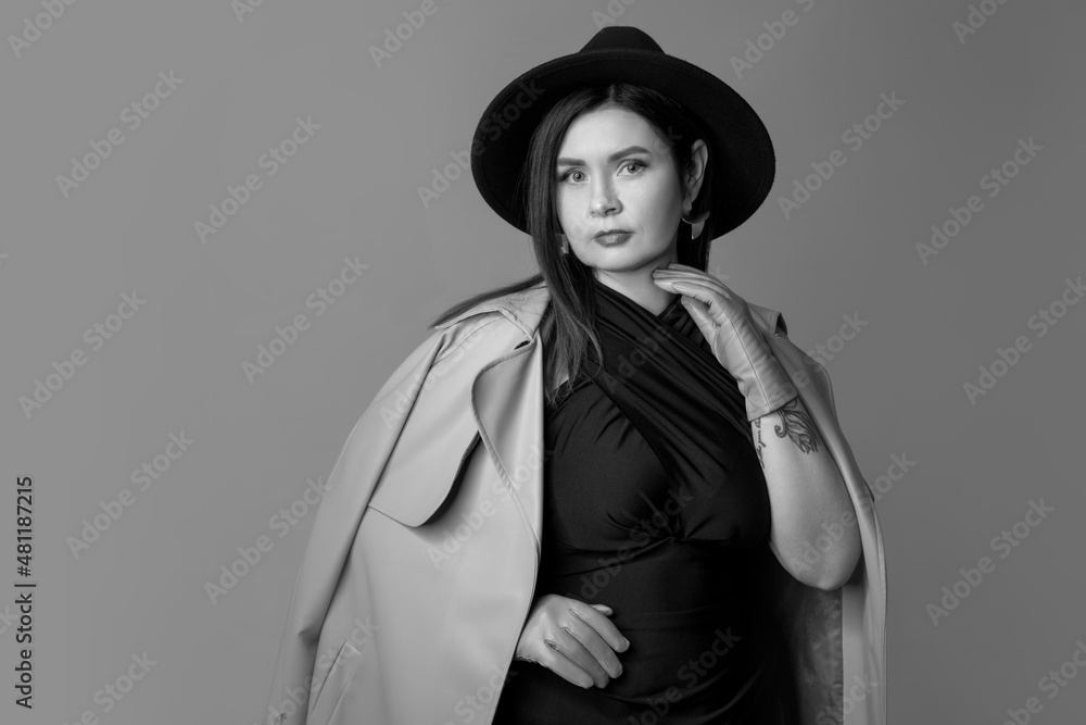 Half-length monochrome portrait of young beautiful woman posing isolated on gray studio background. Beauty, fashion, style, bodypositive concept Half-length monochrome portrait of young beautiful woman posing isolated on gray studio background. Beauty, fashion, style, bodypositive concept