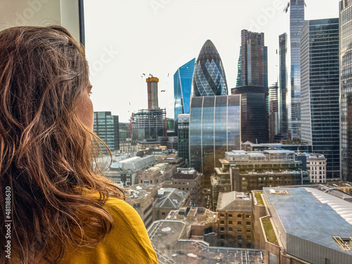 Young woman and London skyline from an apartment in Spitalfields, E1