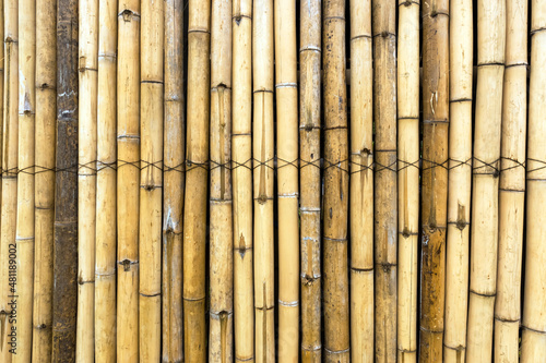 Old brown tone bamboo simple wall or Bamboo fence texture background for interior or exterior design vintage tone. Brown bamboo stick pattern backdrop. Local area urban house protection from thief.