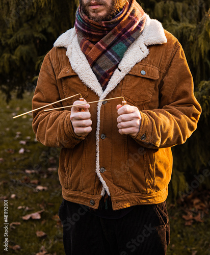 Man holding dowsing rod outside photo