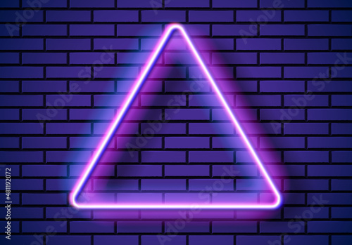 Neon frame with triangle shape on the blue brick wall. Classic rectangular 80s styled purple shiny glowing neon sign.
