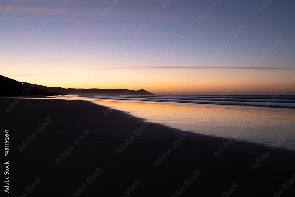 Tregantle Beach in Whitsand Bay Cornwall at sunrise with reflections in the sand and sea