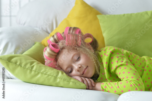 Lovely little girl with pink curlers sleeping