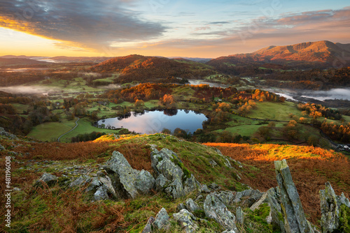 Fotografie, Obraz Beautiful Autumn Sunrise Looking Towards View of Lake District Mountain Range Seen From Loughrigg Fell