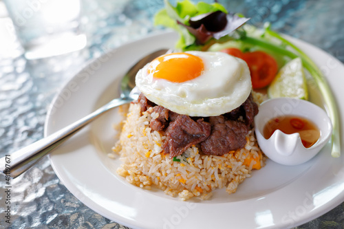 Beef Fried Rice with Fried Egg put on a glass table concept fast food.