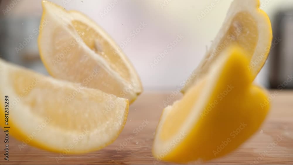 Lemon Slices Falling onto the Wooden Table, Bouncing and Splashing Water Droplets Lemon Slices Falling onto the Wooden Table, Bouncing and Splashing Water Droplets