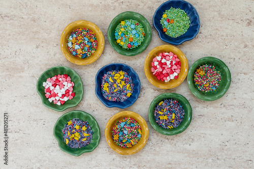 Different colorful ceramic plates with food decor on ceramic tile.