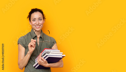 Young woman smiling holding books and glasses