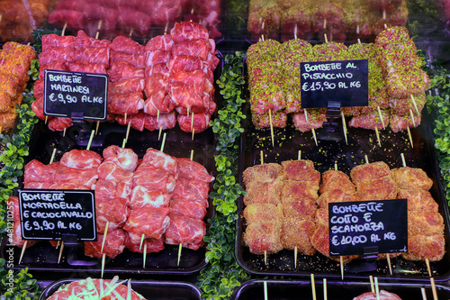 Various types of the famous bombette martinesi for sale in a butcher's shop. Meat rolls stuffed with cheese. In the signs written in Italian the various types of tastes photo