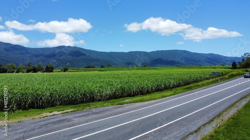 Beautiful Aerial shot of farming fields with a road and mountain backdrop © AspectDrones