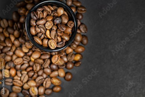 Roasted coffee beans on a black background, banner mockup, selective focus, top view, place for text. © Yarr