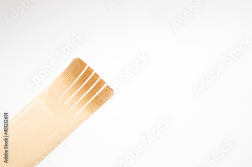 Wooden scratching stick on white background.