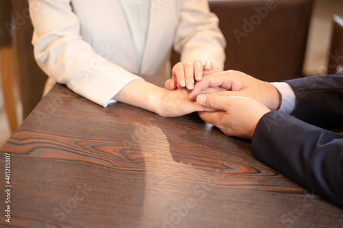 カフェで手をつなぐ恋人夫婦