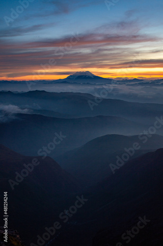 Beautiful lanscape on smaller mountain ranges and Antisana volcano at the back. Different layers of mountains can be seen. 