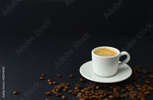 Black coffee and roasted coffee beans on table on a black background, small cup espresso couple, copy space